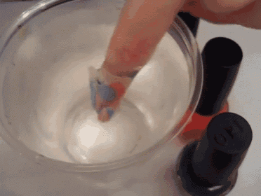 two bottles of opi nail polish are in a bowl