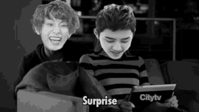 a boy sitting on a couch looking at a tablet with the word surprise written on it
