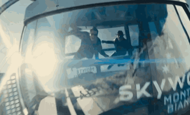 two people are riding a ski lift with the word sky on the side
