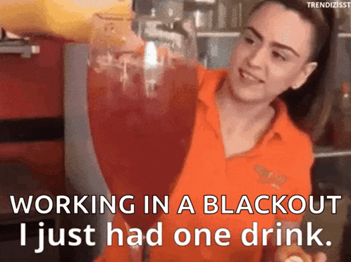 a woman in an orange shirt pours a drink into a glass