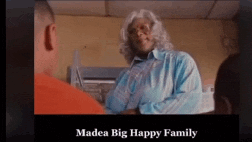 a woman in a blue shirt is talking to a man in an orange prison uniform and the caption says madea big happy family
