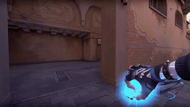 a person is holding a gun in front of a brick wall
