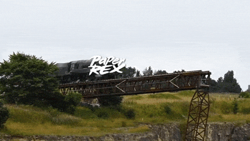 a train is going over a bridge with the words paper rex written on the bottom