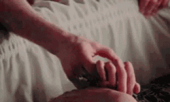 a close up of a person holding another person 's hand .