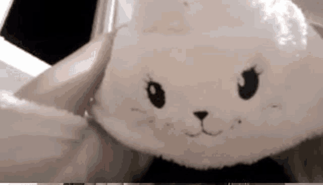 a person is holding a stuffed animal that looks like a bunny .