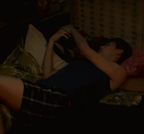 a man in plaid shorts is laying on a bed with his head on a pillow