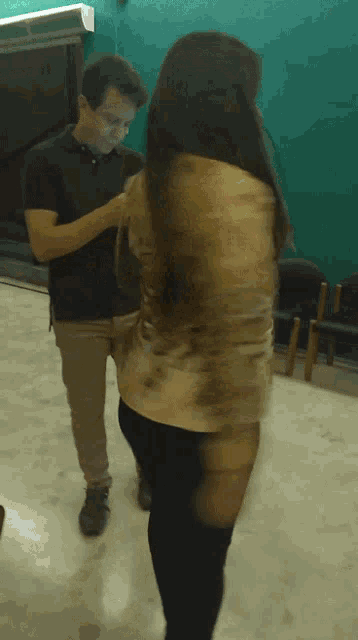 a man and a woman are dancing together in a dark room