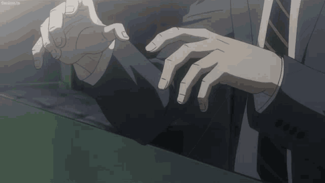 a man in a suit and tie has his hands on his sleeves