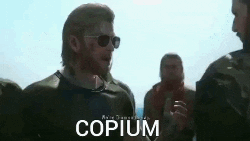 a man with a beard wearing sunglasses is standing in front of a group of men and talking to them .