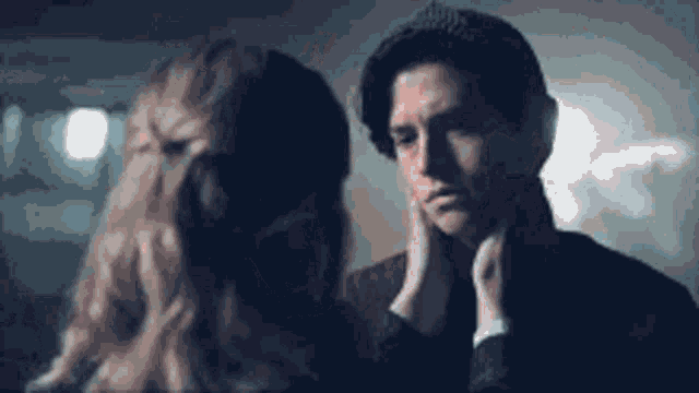 a woman is touching a man 's face in a close up .