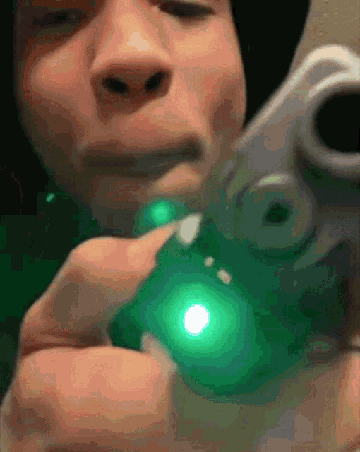 a man is holding a gun with a green light on it .