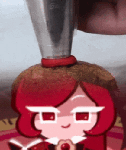 a cartoon character with red hair is being decorated with frosting and a hat .