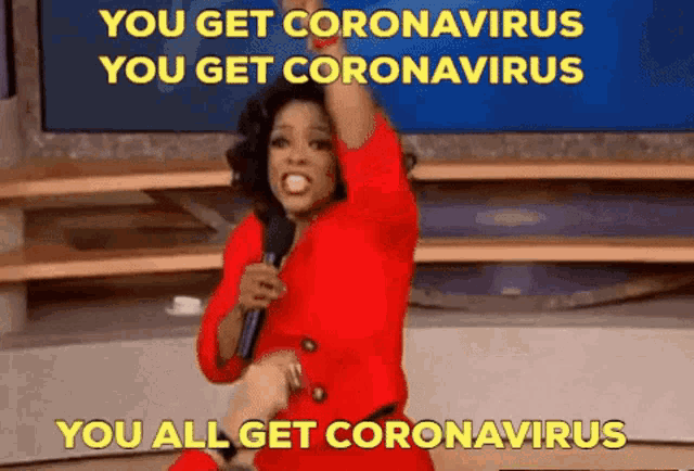 a woman in a red dress is holding a microphone and saying you get coronavirus you get coronavirus you all get coronavirus