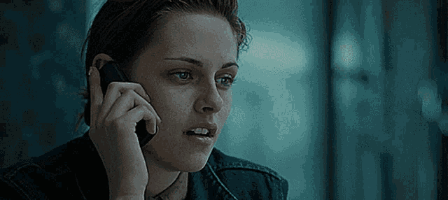a woman in a denim jacket is talking on her cell phone