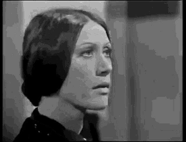 a black and white photo of a woman 's face looking to the side .