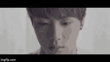 a close up of a young man 's face with a tear coming out of his eye .