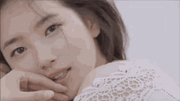 a close up of a woman with her hand on her face .