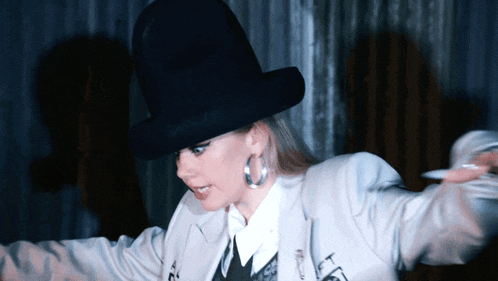 a woman wearing a black top hat and a white jacket