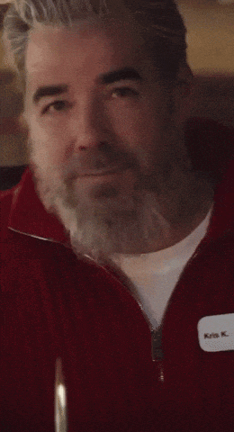 a man with a beard is drinking a glass of milk