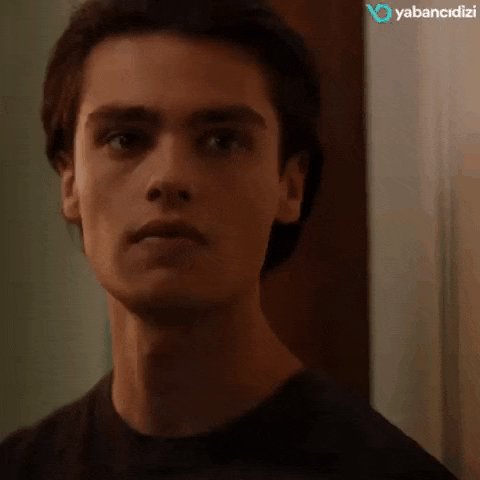 a close up of a young man 's face in a black shirt .