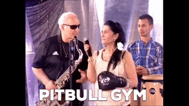 a man playing a saxophone next to a woman wearing boxing gloves with the word pitbull gym on the bottom