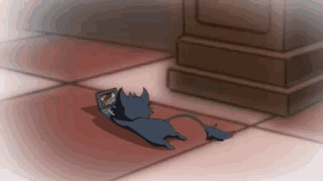 a cartoon cat is laying on the floor with a book in its mouth .