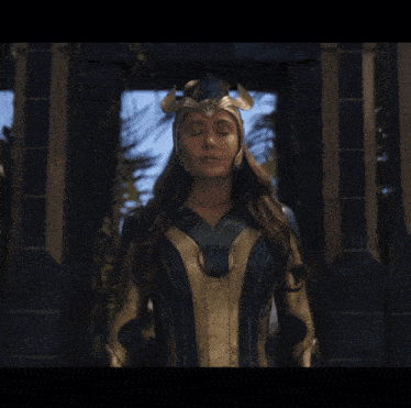 a woman with her eyes closed wearing a blue and gold costume