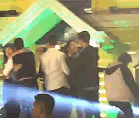 a group of people are gathered in a dark room