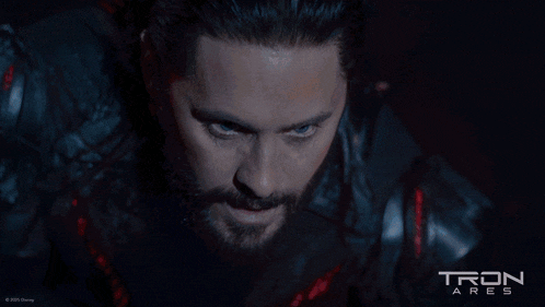 a man with a beard and a tron ares poster