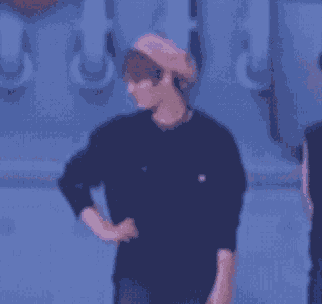 a blurry picture of a man wearing a hat and a black shirt .