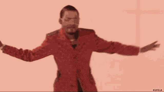 a man in a red jacket is dancing in front of a cross .