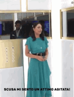 a woman in a green dress stands in front of a mirror and says scusa mi sento un attimo agitata !