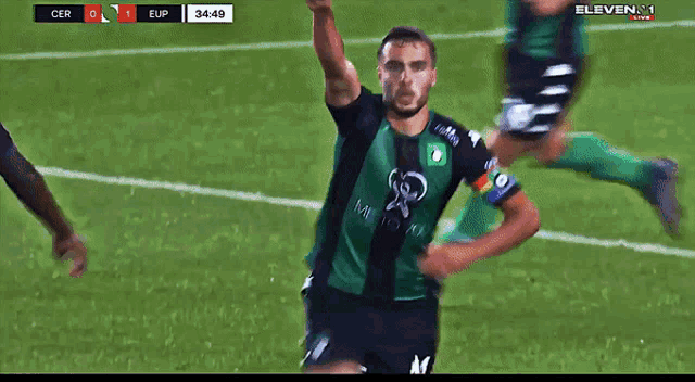 a soccer player in a green jersey is running on the field during a match
