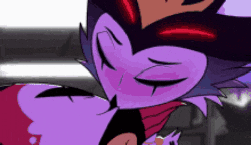 a close up of a purple and red cartoon character with a crown on its head .