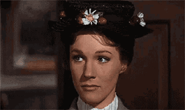 mary poppins is wearing a hat with flowers on it and her eyes closed .