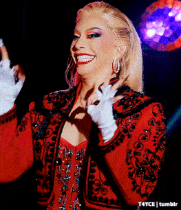 a woman in a red jacket and white gloves is smiling .