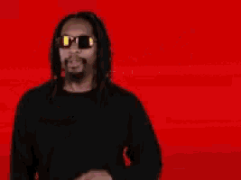 a man wearing sunglasses is giving the middle finger in front of a red background that says happy f * cking birthday