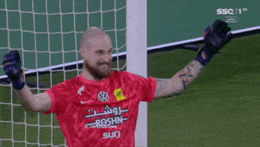 a soccer player in a red shirt with roshn on it