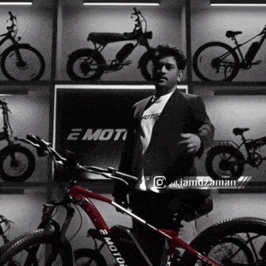 a man in a suit stands in front of a display of e motor bikes