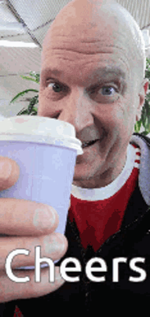 a man is holding a cup that says cheers on the bottom