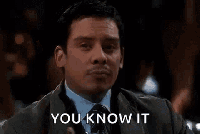 a man in a suit and tie is holding a glass of water and saying `` you know it '' .