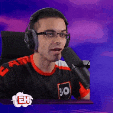 a man wearing headphones and a shirt with the number 30 on it is talking into a microphone ..