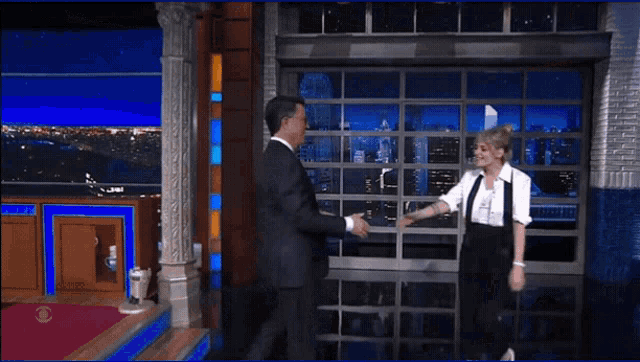 a man in a suit and a woman in a white shirt are hugging each other