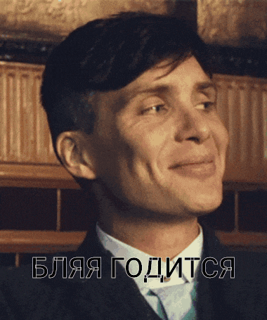 a man in a suit and tie is smiling in front of a foreign language text
