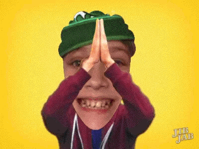 a boy wearing a green hat is making a funny face