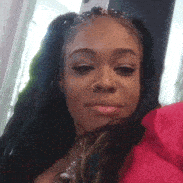a woman with pigtails and a nose ring is taking a selfie .