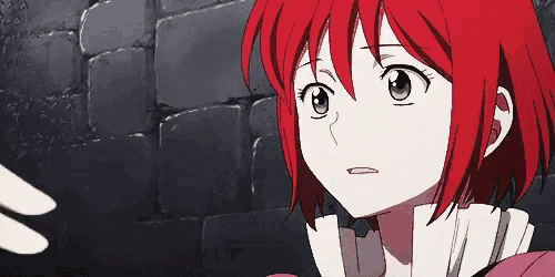 a girl with red hair and green eyes is standing in front of a brick wall