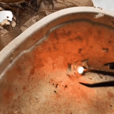 a close up of a bowl of orange liquid with a light coming out of it