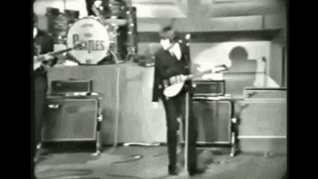 a black and white photo of a beatles band on stage