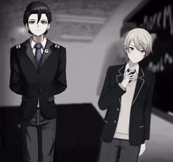 a man in a suit and tie stands next to another man in a suit and tie in front of a blackboard
